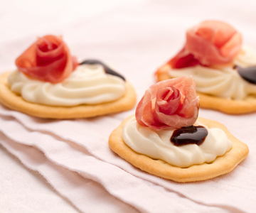 Platbrood met squacquerone-crème en culatello