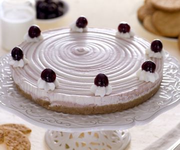 Twee-kleurige cheesecake met room en kersen