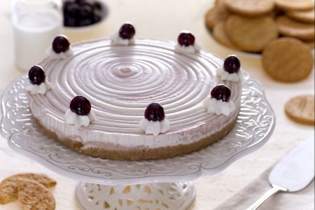 Twee-kleurige cheesecake met room en kersen