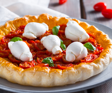 Hartige taart met knoopjes en geconfijte cherrytomaatjes