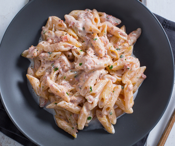 Penne met romige tomatensaus en ham