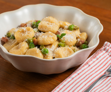 Ricotta-gnocchi met doperwten, pecorino en guanciale