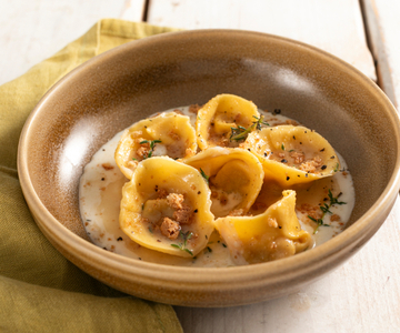 Cappellacci gevuld met pompoen en amaretti op provola-fondue