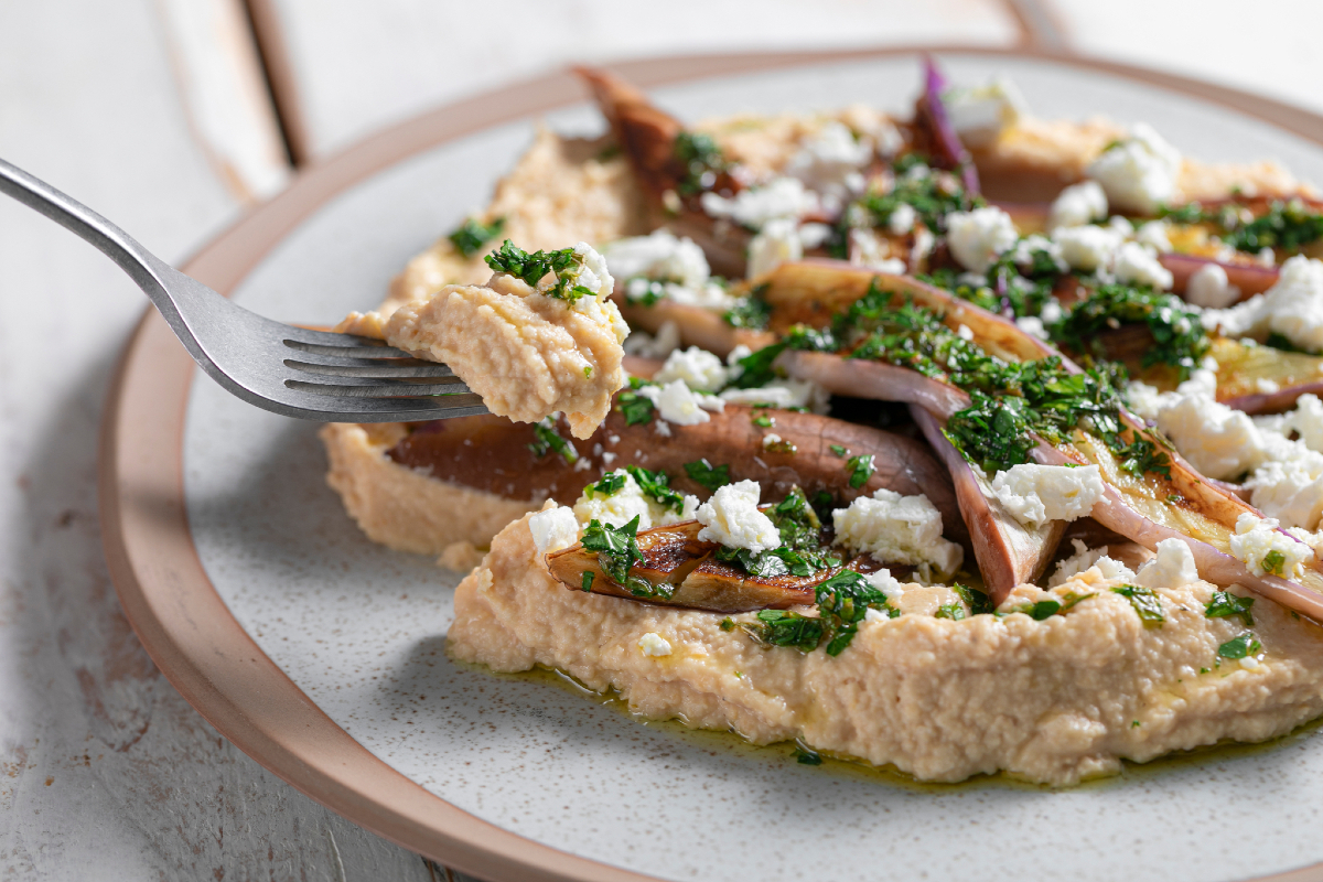 In de pan gebakken aubergines met hummus en feta