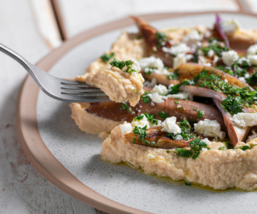 In de pan gebakken aubergines met hummus en feta